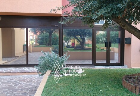 Office with shopping window opening on a communal garden